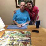 Older man and woman at a table with a jigsaw puzzle, showcasing The Darville Company's team and collaboration.