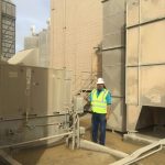 Worker in safety gear near large machinery at The Darville Company&rsquo;s industrial site, emphasizing safety and professionalism.
